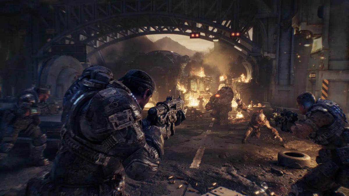 Soldaten in zware bepantsering in gevecht met monsters in een verwoeste stedelijke omgeving uit Gears of War: E-Day.